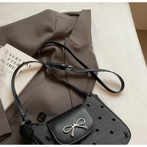 Detailansicht der grauen Handtasche mit Fischgrätenmuster, Punkten und Silberverschluss