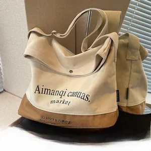 Détail du sac cabas en toile contrastée avec large bandoulière et boucle en métal