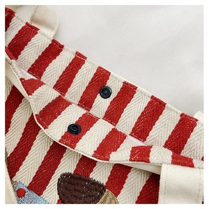 Vue détaillée du sac seau en toile rayée rouge et blanc avec boutons-pression noirs