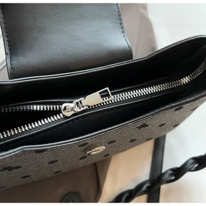 Detailansicht des oberen Reißverschlusses und des Schleifenmusters auf der Schultertasche