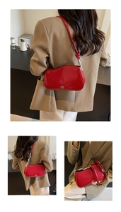 Close-up of bright red leather shoulder bag with wavy edge and knotted strap detail