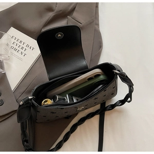 Detailansicht einer gepunkteten Schultertasche mit Platz für Handy und Parfüm im Inneren