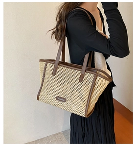 Détail du sac cabas en paille HOCOMU avec bordures en cuir marron et bandoulière
