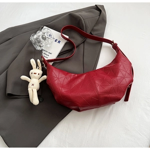Red half-moon shoulder bag with geometric embossing and a beige bunny plush charm