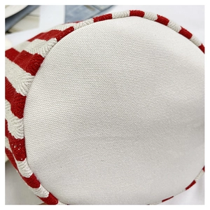 Vue rapprochée de la base ronde en toile du sac seau à rayures rouges et blanches
