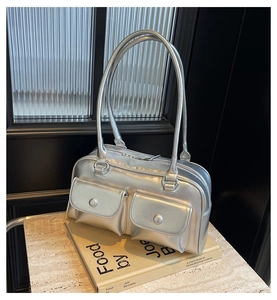 Gros plan du sac Boston argenté avec poches cargo sur comptoir en marbre
