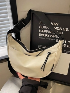 Minimalist beige dumpling canvas crossbody bag with adjustable black strap and zipper