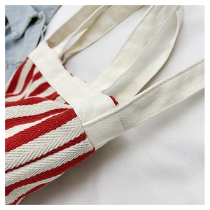 Gros plan du sac seau en toile à rayures rouges et blanches avec poignées renforcées