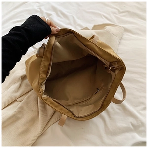 Interior view of khaki nylon tote bag showing main compartment and zipper pocket