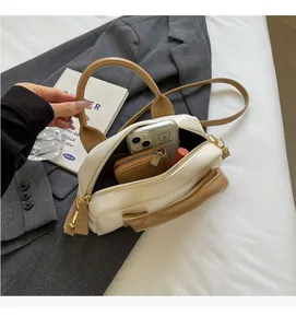 Top view showing the large capacity and interior of the cream and brown crossbody bag