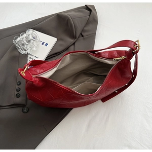 Top-down view of red handbag showing interior compartments and diamond-textured surface