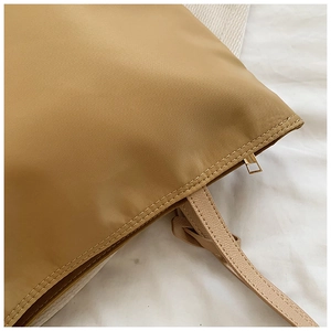 Macro view of khaki oxford fabric texture and golden metal zipper detail of the tote