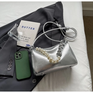 Detail der silbernen Falten-Umhängetasche mit Perlenriemen und Herzanhängern
