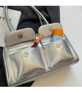 Détail d'un sac à main argenté métallisé avec deux poches avant pour cosmétiques