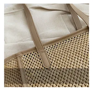 Détail d'un sac en paille tressée montrant la poignée en similicuir et coutures