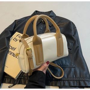Detail of white Boston bag with camel straps, gold hardware and leather texture