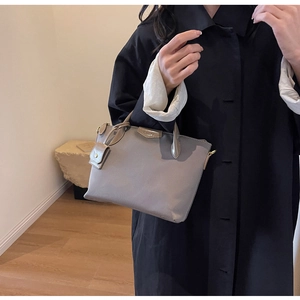 Detail of grey-purple Oxford cloth tote with leather trim and decorative mini pouch