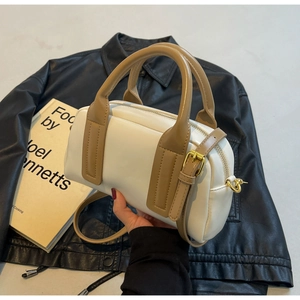 Detail of two-tone Boston bag with cream PU leather and khaki handles and strap