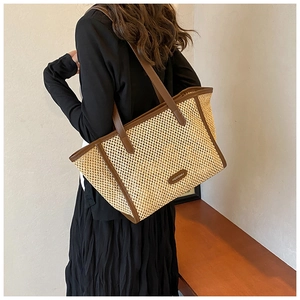 Détail du sac cabas en paille avec bordures en cuir marron et texture de tissage