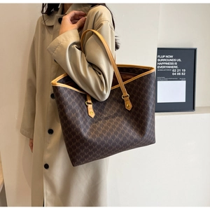 Macro detail of retro monogram printed tote bag showing luxury texture and stitching
