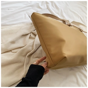 Detailed side view of khaki nylon tote bag showing high-quality stitching and texture