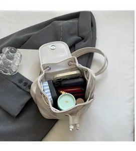 Internal layout of cream leather mini backpack showing capacity for phone and makeup