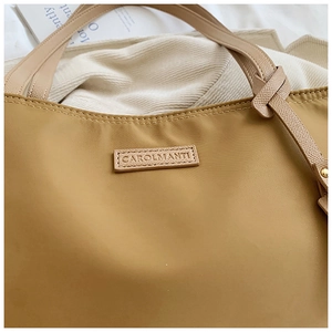 Detail of khaki oxford fabric texture with leather brand tag and handle on tote bag