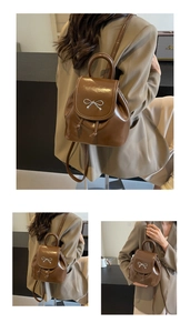 Detail of brown mini backpack with silver bow buckle and drawstring closure in use
