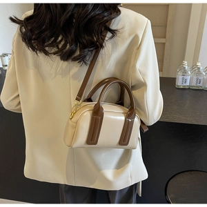 Model view of vintage cream Boston bag with brown handles and detachable shoulder strap