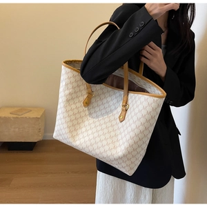 Detail of the large monogram tote bag with leather straps on a stylish model