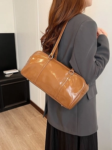 Retro brown glossy leather large capacity tote bag shown from a stylish side view angle