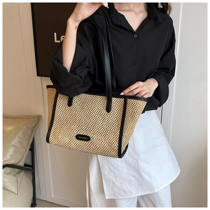Détail du grand sac cabas en paille avec bordure en cuir noir et logo de marque HOCOMU