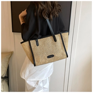 Détail du grand sac cabas en paille avec bordure en cuir noir et logo HOCOMU