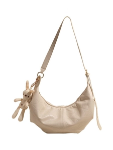 Chic off-white crescent crossbody bag with geometric texture and cute plush bunny charm