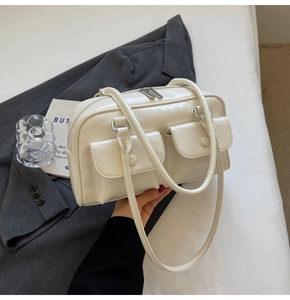 Détail d'un sac en cuir PU blanc cassé avec deux poches à rabat et fermeture éclair métallique