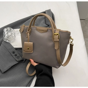 Detail of oxford fabric tote with CLEAOK logo and decorative mini pouch accessory