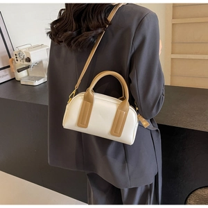 Detail of Boston bag with leather handles and detachable strap worn on the shoulder