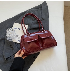 Détail du sac à main en cuir verni bordeaux avec poches à rabat et boucles argentées