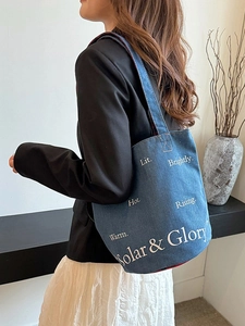 Borsa a secchiello in denim blu con scritte bianche per look casual estivo da donna