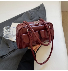 Détail du sac bandoulière en cuir verni bordeaux avec double poches à rabat avant