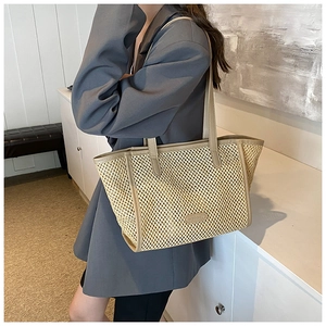 Détail de la texture tissée et des finitions en similicuir sur le grand sac cabas beige