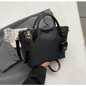 Detail of black nylon tote bag with glossy leather handles and gold CLEAOK hardware