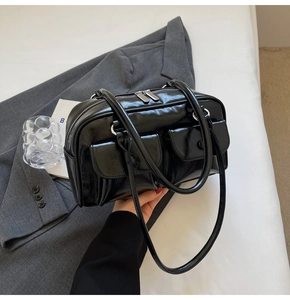 Détails du sac en cuir verni noir avec fermetures argentées et doubles poches avant