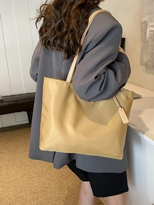Large khaki oxford tote bag shown on a model with grey blazer for office commuting