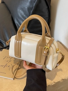 Elegant cream and khaki Boston bag with gold hardware and adjustable shoulder strap