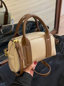 Elegant two-tone Boston handbag in beige and brown leather with gold metal zippers