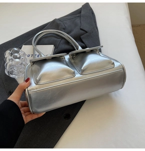Détail du sac argenté métallisé avec deux poches avant et fines poignées supérieures