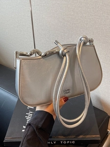 Silver metallic leather shoulder bag with wavy metal hardware and knotted rope handles