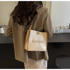 Detail of minimalist tote bag showing contrast stitching and gold twist lock closure