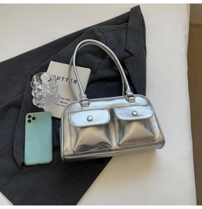 Détail du sac argenté métallisé avec deux poches frontales et texture miroir lisse
